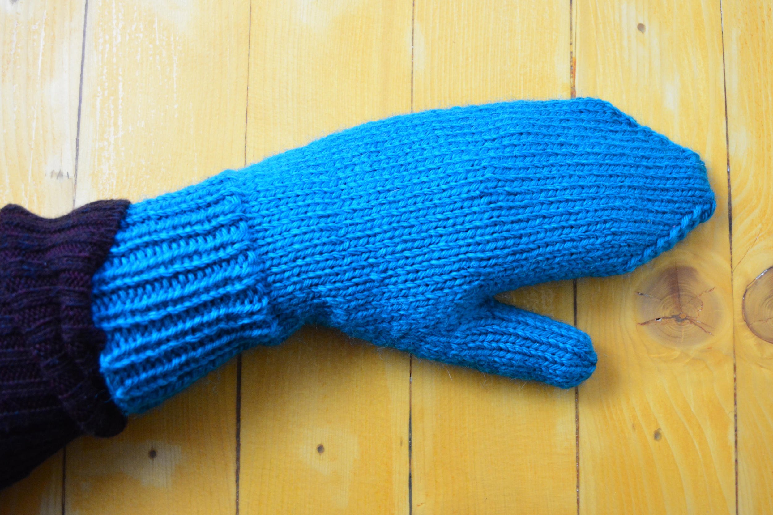 A woman’s hand wearing the Size 3 mittens.